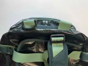Locate the D-rings on one end of the duffel. They're on your left when the duffel is laying on its bottom with the front pocket facing you.