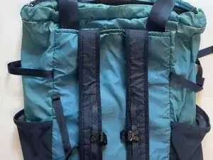 Find the bottom stash pocket along the bottom edge of the back of the tote.