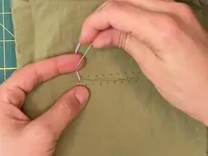 Continue the stitch, alternating sides and always bringing the needle up inside the tear.