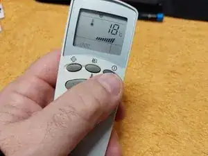 Disassembly and cleaning of the remote control for an LG air conditioner due to a button malfunction.
