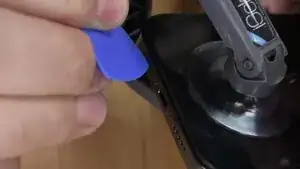 Once the screen has slightly lifted, carefully insert the pick into the small opening. Gently work the pick around the entire perimeter of the screen to release the adhesive/clips. This process will allow the screen to lift freely and be safely removed.