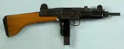 Uzi com coronha de madeira.