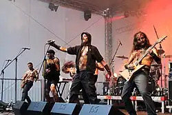 a banda ao vivo fotografada de um ponto um pouco abaixo do palco e à esquerda do mesmo