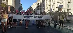 Imagem da manifestação pelo direito à casa em Lisboa, em 30 de Setembro de 2023. A imagem mostra várias pessoas com uma faixa que diz: moradores afectados pela expansão do Metro; por diálogo e realojamento! Esta manifestação ocorreu por protesto à escassez de habitação e especulação imobiliária em Portugal que levou a vários despejos.