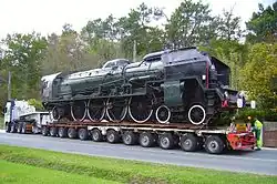 Uma locomotiva em um carreta especial para carga superdimensionada.