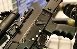 Uma visão mais próxima do lado direito veja o seletor de tiro ambidestro, a versão do botão pressionado e a porta de ejeção do modelo de protótipo proposto inicialmente cancelado do AK-12.