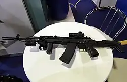 Uma visão do lado esquerdo do modelo de protótipo proposto inicialmente cancelado do AK-12. Observe a porta de ejeção ambidestra e a alavanca de armar reversível acima do cabo dianteiro vertical.