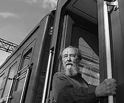 A black-and-white image of Aleksandr Solzhenitsyn outside a building.