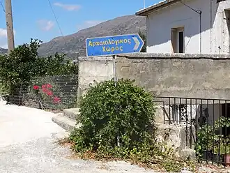 Edifício de Monastirací com uma placa indicando a localização do sítio arqueológico homônimo