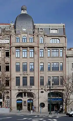 Fotografia do edifício que albergava o Jornal de Notícias entre 1926 e 1970, projectado por Marques da Silva. O edifício tem 6 pisos e fachada com estilo de influência francesa, em granito com telhados de xisto.