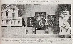 Foto da instalação da sala cubista, publicada no New York Tribune, 17 de fevereiro de 1913 (p.&nbsp;7). Da esquerda para a direita: Raymond Duchamp-Villon, La Maison Cubiste (Projet d'Hotel), Casa cubista; Marcel Duchamp Nu (Estudo), Jovem Triste em um Trem; Albert Gleizes, L'Homme au Balcon, Homem na Varanda; Marcel Duchamp, Nude Descending a Staircase, No. 2 ; Alexander Archipenko, La Vie Familiale, Family Life