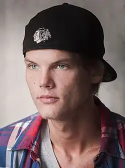 Avicii olhando para a direita, usando um boné preto.