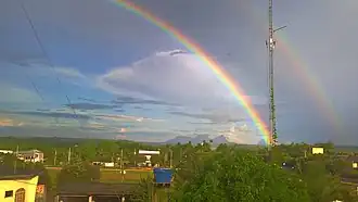 Um arco-íris sobre a cidade, com a Serra da Bela Adormecida ao fundo.
