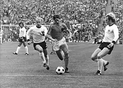 O alemão Gerd Müller (esquerda) observa o holandês Johan Cruyff (centro) entre os companheiros de equipa Berti Vogts (2ª à esquerda) e Uli Hoeness (à direita).