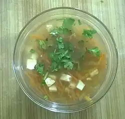 Uma sopa de cenoura e mamão preparada como caldo, com cenouras cortadas em julienne