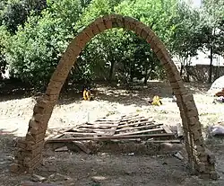 Arco em forma de catenária invertida de tijolos de barro.
