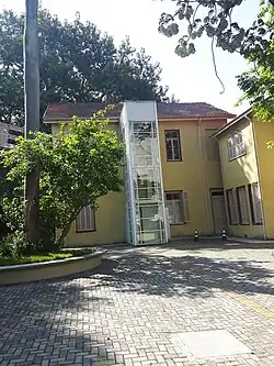 Fundo da Chácara Lane, onde se vê um elevador e o estacionamento