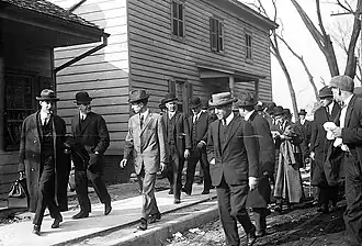 Charles Becker sendo escoltado para cadeia, onde tempos depois seria executado