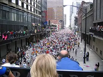 A massa de corredores atravessa a Grand Avenue no centro de Chicago.