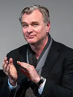Foto do diretor Christopher Nolan aplaudindo em um painel "Em Conversa" no teatro Southbank do British Film Institute em fevereiro de 2024.