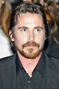 Retrato do ator galês Christian Bale com o olhar direcionado à direita da câmera.