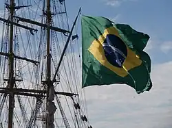 Bandeira nacional brasileira içada no penol da carangueja do navio veleiro Cisne Branco