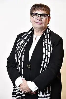 Isilda Maria está no centro da imagem com fundo branco