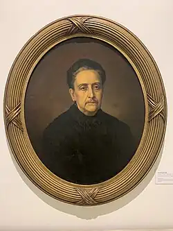 Retrato em meio corpo, de frente, da Condessa de Rio Novo (Senhora Mariana Claudina Pereira de Carvalho) representada com cabelos penteados para trás, buço aparente e trajando indumentária preta. Dimensão: A 72.0 X L 59.0 cm