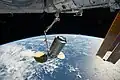 O Canadarm recolhe a nave de suprimentos Cygnus.