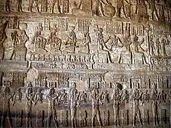 Fotografia manipulada digitalmente de uma parede interna no mammisi, destacando o baixo-relevo