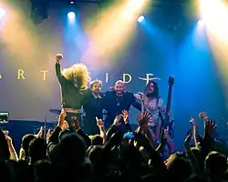 Imagem em preto e branco de quatro músicos num palco