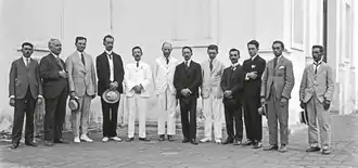 Imagem de doze homens de terno e um do lado do outro. Começando da esquerda, o primeiro é Luiz Rodrigues, o segundo é Theophilo Lee, o terceiro é Daniel Wise, o quarto é Henrique Morize, o quinto é Charles Davidson, o sexto é Andrew Crommelin, o sétimo é Allyrio de Mattos, o oitavo é Andrew Thomson, o nono é Domingos Costa, o décimo é Lelio Gama (ao qual o artigo presente se refere), o décimo primeiro é Antonio Lima e o décimo segundo é Primo Flores. Todos estão no Observatório Nacional.