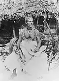 Tuimanuʻa Elisala Alalamua, o último chefe Tui Manu'a (1899–1909) segurando um "fue" em sua mão direita