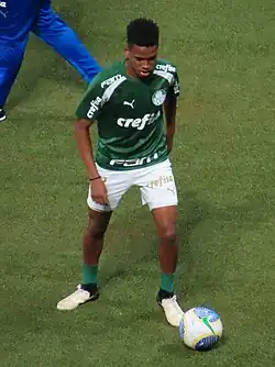 Um jogador se preparando para chutar uma bola com o pé esquerdo
