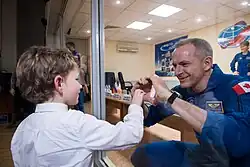 David Saint-Jacques despede-se do filho através do vidro da sala de quarentena antes do lançamento.