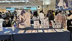 Estande com diversos livreto de dōjinshi e artes yuri
