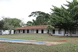 A fotografia mostra a área posterior do terreno da Casa Niemeyer, parte de seu jardim e de sua piscina.