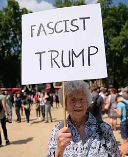 Mulher idosa carregando um cartaz onde Trump é chamado de fascista (Londes, 2018).