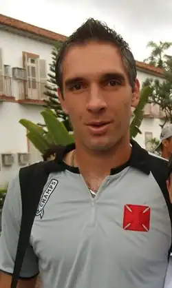 Um homem olhando pra câmera e com um sorriso leve