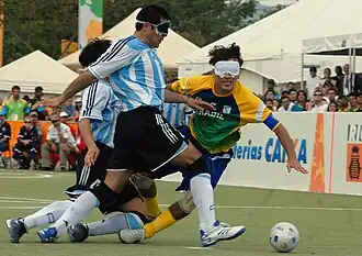 two Argentinian players and one from Brazil running after the ball or falling down