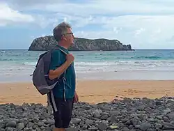 Foto do professor Paulo da Cunha Lana na praia com uma mochila nas costas