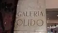 Gravura em mármore na parede de entrada da Galeria Olido.