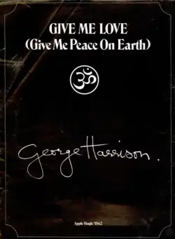 Um fundo preto com finas bordas brancas. No topo da página, em letras brancas, o nome da canção: "Give Me Love (Give Me Peace on Earth)". Logo abaixo, o símbolo da mantra Om dentro de um círculo branco. Mais abaixo, a assinatura de George Harrison. Ao fim da página, os dizeres: "Apple Single 1862".