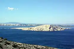 Photograph of a small rocky island at a short distance from the mainland shore