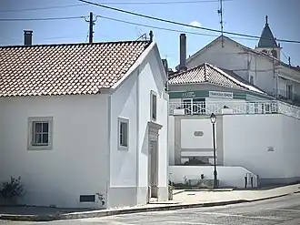 Capela do Senhor Bom Jesus dos Aflitos em primeiro plano; torre sineira da Igreja de Nossa Senhora de Fátima ao fundo