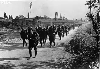 Soldiers marching down a road