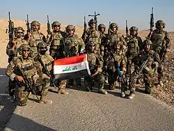 Operadores do ISOF segurando uma bandeira do Iraque