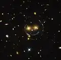 "Imagem de Smiley" – aglomerado de galáxias (SDSS J1038+4849) & lente gravitacional (um anel de Einstein) (Hubble).[16]