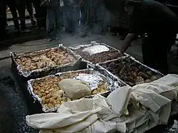 Um Hāngi sendo preparado, um método Māori da Nova Zelândia de cozinhar alimentos para ocasiões especiais usando pedras quentes enterradas em um forno de cova.