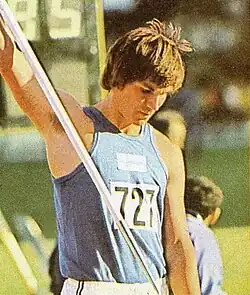 Hannu Siitonen, homem branco com cabelos pretos, regata azul com o número 727 parcialmente visível, segurando uma vara de salto.